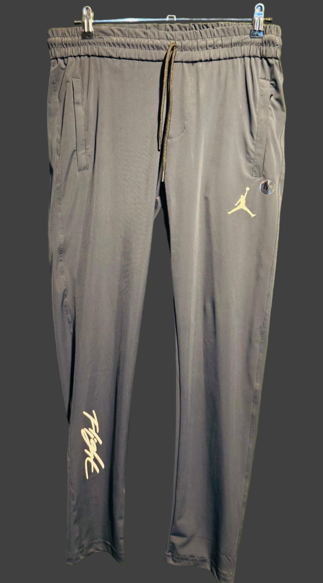 Gray pants with yellow logos on a dark background